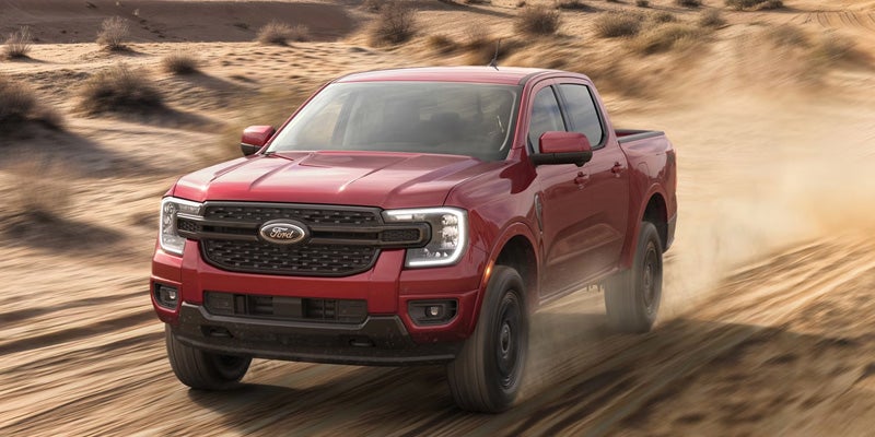 Red Ford Ranger kicking up dirt off-road