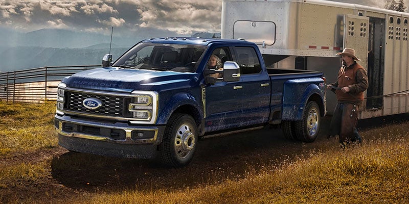 Blue Ford Super Duty towing a horse trailer