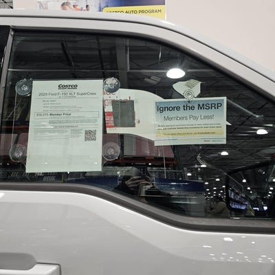 Costco Auto Program signs displayed in the window of a Ford F-150 at Costco
