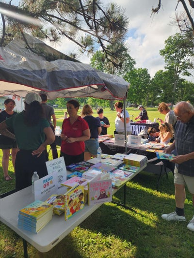 Young readers picking out books at the Storytime in the Park event